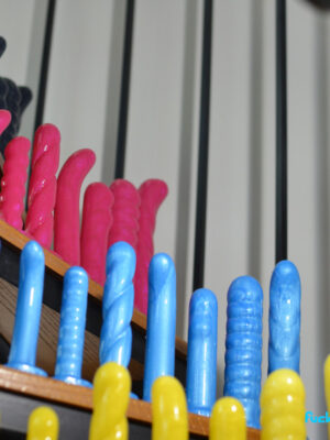rows of NoFrilldos arranged with one of each shape in four rows of each color, arranged on a spiral staircase