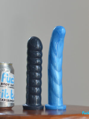 two larger NoFrillDo dildos, the X and L. The X is thick and ribbed, the L is long and has a curve and ridges.