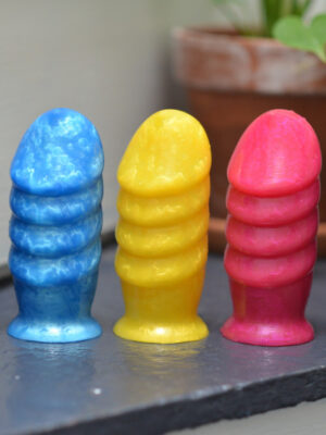 a set of girthy sex toys arranged by color. They have four thick ridges and a tapered head.