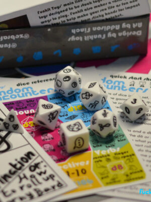 7 sex dice atop some beautifully printed, colorful guides and games.