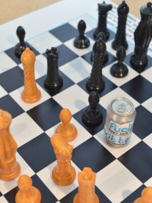 a game of Funkit Chess in mid play, with a soda can for scale.