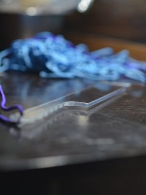 a clear acrylic paddle with a paracord strap