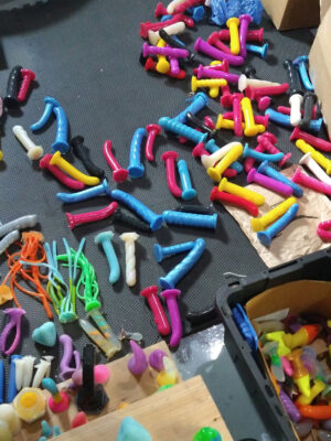 a lot of unusable dildos, with some oddities thrown in, strewn about a basement floor mid-organization rampage.